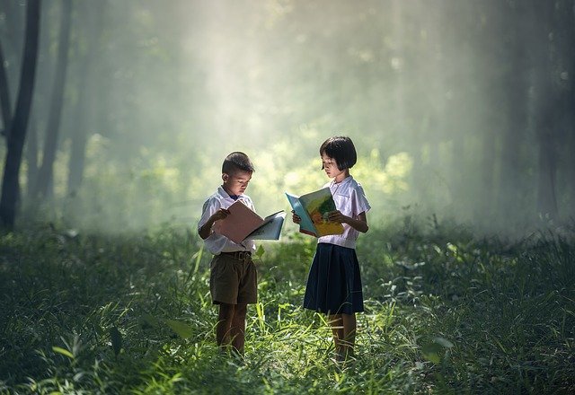 kids reading a book in a forest