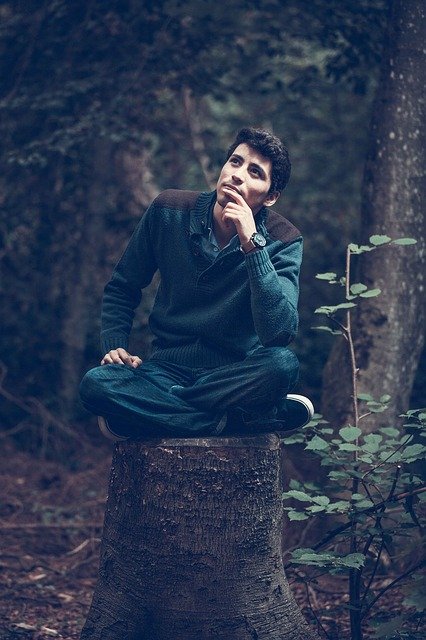 man thinking on a tree trunk